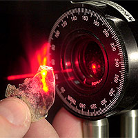 Cliff Johnston uses a laser to look at a clay particle in his Purdue University lab. The laser helps Johnston study the structure and orientation of the clay. This particular layer is approximately 1 million times the thickness of the one nanometer-thick layer researchers recently developed. (Purdue Agricultural Communications photo/Tom Campbell)
