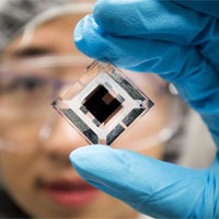 <p>Xiaozhou Che, EECS Graduate Research Assistant, holds an organic tandem photovoltaic cell in the EECS Building on April 20, 2018. Image credit: Joseph Xu</p>
