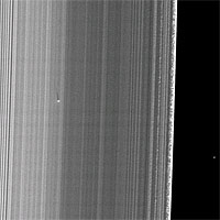 <p>
	The Cassini spacecraft captured this image of a small object in the outer portion of Saturn's B ring casting a shadow on the rings as Saturn approached its August 2009 equinox.</p>
<p>
	The new object, situated about 650 kilometers (400 miles) inward from the outer edge of the B ring, was found by the presence of a localized bright feature and the detection of its shadow, which stretches 36 kilometers (22 miles) across the rings. Cassini scientists suspect the object is a solid moonlet, as opposed to a diffuse debris cloud, as might result from an impact, because no shadows have been observed accompanying any known impact plumes observed by Cassini. The shadow's length implies that the moonlet is protruding about 150 meters (500 feet) above the ring plane. If the moonlet is orbiting in the same plane as the ring material surrounding it, which is likely, it must be about 300 meters (1,000 feet) from bottom to top. However, the width of the bright feature implies that the moonlet must be several times wider than that height.</p>
<p>
	Unlike the band of moonlets discovered in Saturn's A ring earlier by Cassini (see PIA07792 and PIA07790), this object is not attended by a long propeller feature. However, the relatively large width of the bright features relative to the height implied by the long shadow may indicate that a fairly localized, perhaps truncated propeller feature surrounds a roughly spherical body that is not directly imaged. The A ring moonlets, which also have not been directly imaged, were found because of the propeller-like narrow gaps on either side of them that they create as they orbit within the rings. The lack of an extended propeller feature surrounding the new moonlet may not be not surprising because the B ring is dense, and the ring material in a dense ring would be expected to fill in any gaps around the moonlet more quickly than in a less dense region like the mid-A ring. Alternatively, it may simply be harder in the first place for a moonlet to create propeller-like gaps in a dense ring.</p>
<p>
	Straw-like patterns of clumping ring material are also visible along the edge of the outer B ring near the right of this image. See PIA09855 to learn more about these features.</p>
<p>
	This image and others like it (see PIA11656 and PIA11659) are only possible around the time of Saturn's equinox which occurs every half-Saturn-year (equivalent to about 15 Earth years). The illumination geometry that accompanies equinox lowers the sun's angle to the ring plane and causes out-of-plane structures to cast long shadows across the rings.</p>
<p>
	This view looks toward the sunlit side of the rings from about 42 degrees below the ring plane. Background stars are visible on the right of the image. They appear elongated by the camera's exposure time.</p>
<p>
	The image was taken in visible light with the Cassini spacecraft narrow-angle camera on July 26, 2009. The view was obtained at a distance of approximately 296,000 kilometers (184,000 miles) from Saturn and at a Sun-Saturn-spacecraft, or phase, angle of 120 degrees. Image scale is about 1 kilometer (4,680 feet) per pixel.</p>
