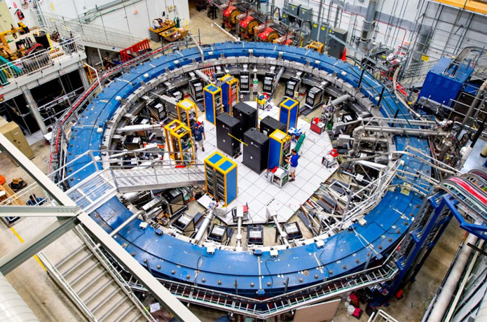 <p>The muon g-2 ring sits in its detector hall amidst electronics racks, the muon beamline and other equipment at the U.S. Department of Energy’s Fermi National Accelerator Laboratory. This experiment studies the precession (or wobble) of muons as they travel through the magnetic field.</p>

<p>Courtesy: Fermi Lab</p>
